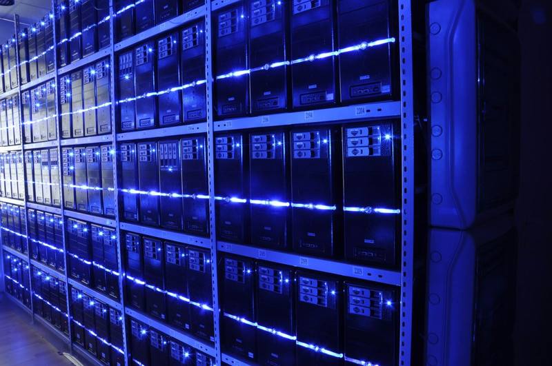 Rows of servers lit by blue LED strips in a data center
