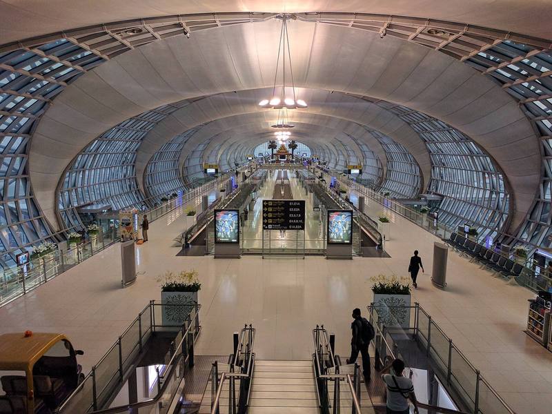 Vast curved airport concourse with travellers seen from above